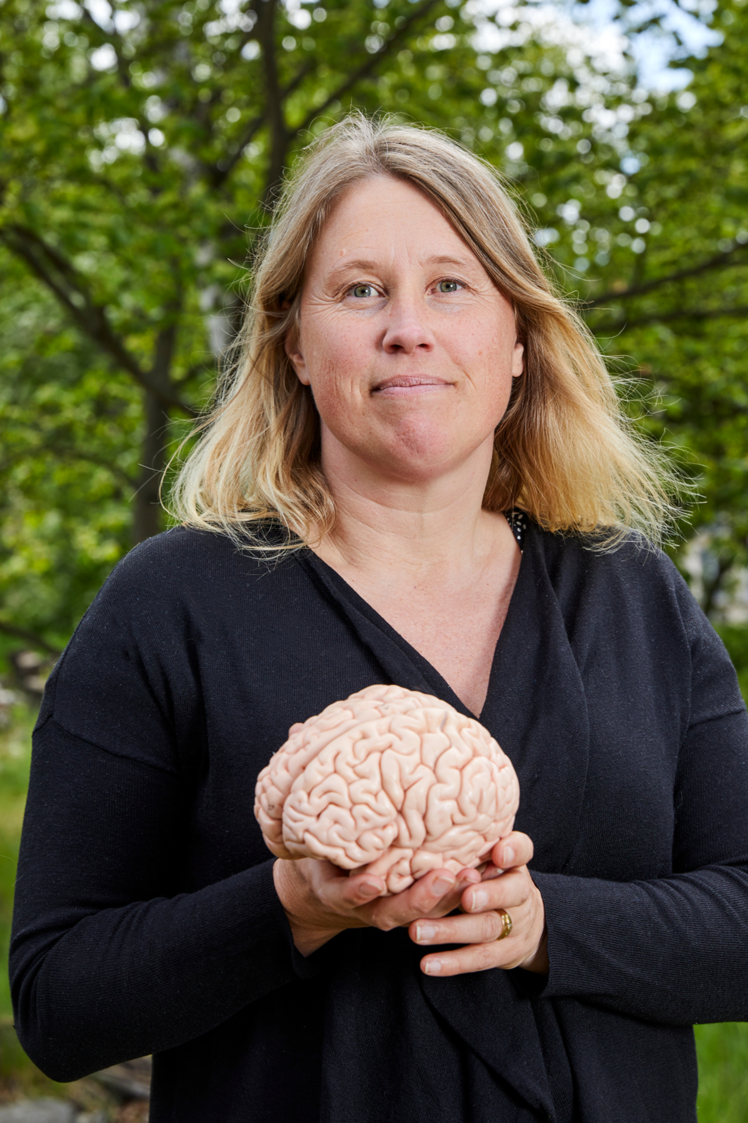 Maria Ekblom utomhus med en hjärna i handen