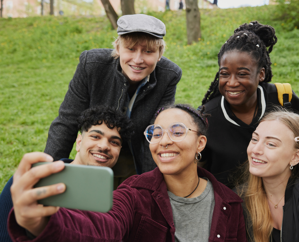 Grupp unga personer som tar en selfie