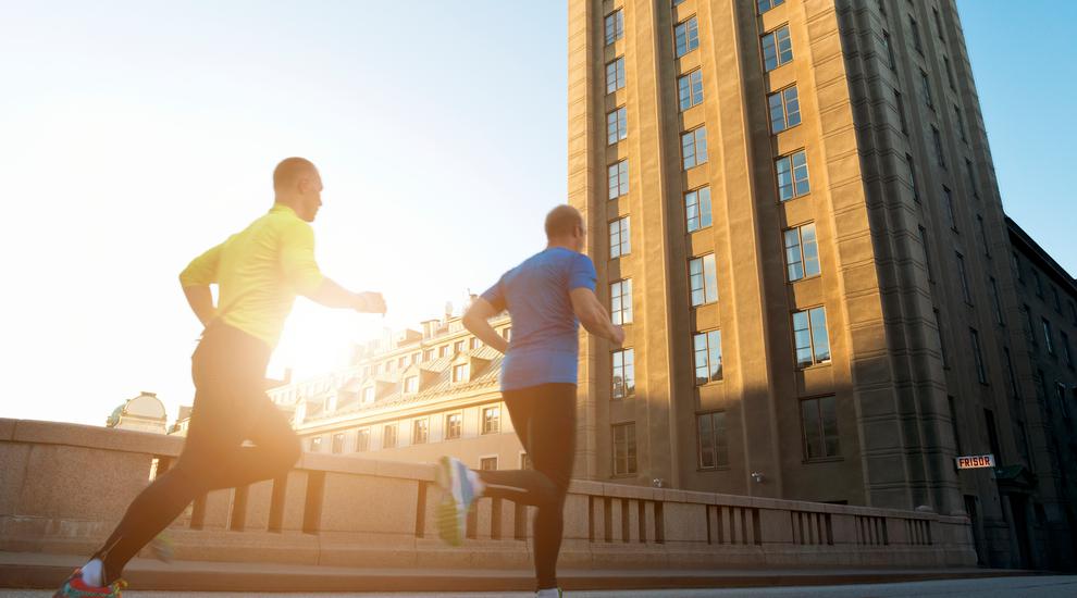 Bilden visar två män som joggar i stadsmiljö
